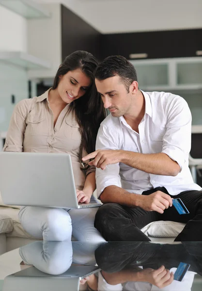 Fröhliches Paar entspannt sich und arbeitet zu Hause am Laptop — Stockfoto