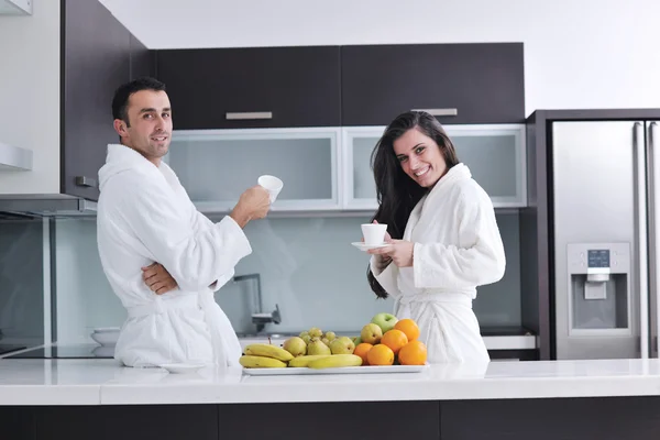 Glada par läser tidningen i köket till frukost — Stockfoto