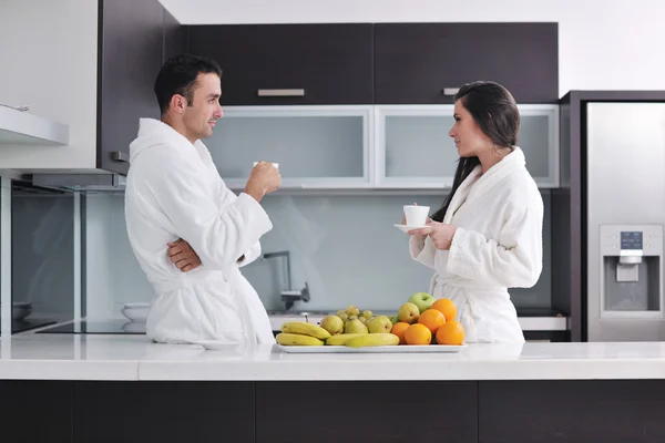 Glückliches Paar beim Zeitungslesen in der Küche beim Frühstück — Stockfoto