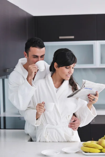 幸せなカップルは、朝食時に台所で新聞を読んで — ストック写真