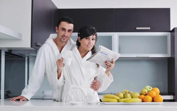 Mutlu çift kahvaltıda mutfakta gazete okuyor. — Stok fotoğraf