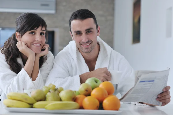 stock image Happy couple reading the newspaper in the kitchen at breakfast