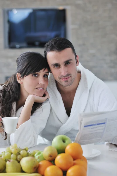 stock image Happy couple reading the newspaper in the kitchen at breakfast