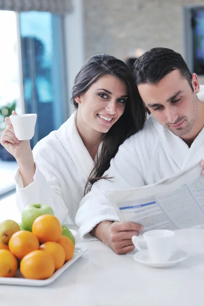 Šťastný pár čtení novin v kuchyni u snídaně — Stock fotografie