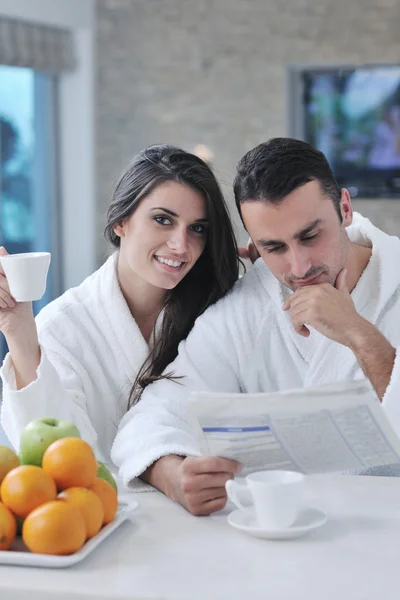 stock image Happy couple reading the newspaper in the kitchen at breakfast