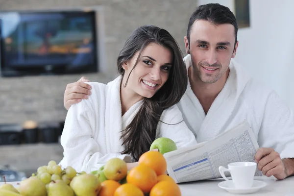 Mutlu çift kahvaltıda mutfakta gazete okuyor. — Stok fotoğraf