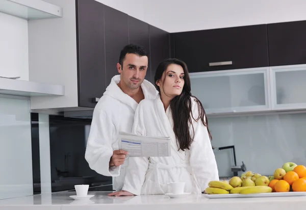 Ευτυχισμένο ζευγάρι διαβάζει εφημερίδα στην κουζίνα στο πρωινό — Φωτογραφία Αρχείου