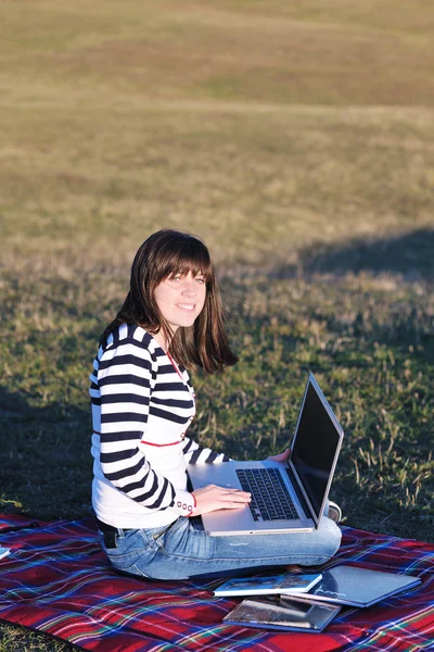 Jong meisje werk op laptop buiten — Stockfoto