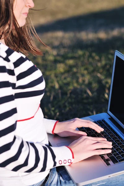 Chica joven de trabajo en el ordenador portátil al aire libre —  Fotos de Stock