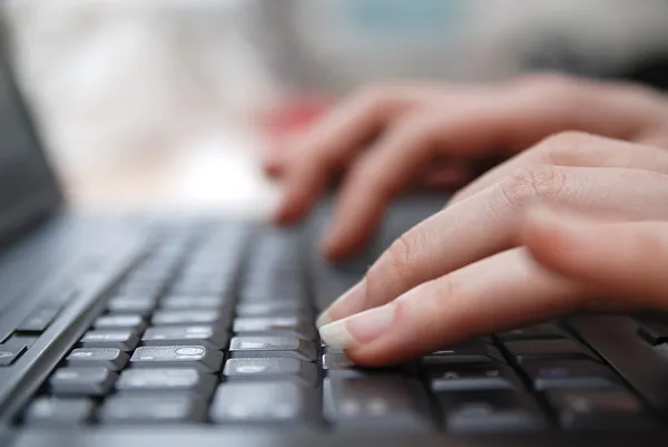 Mujer manos escribiendo en el teclado del ordenador portátil — Foto de Stock