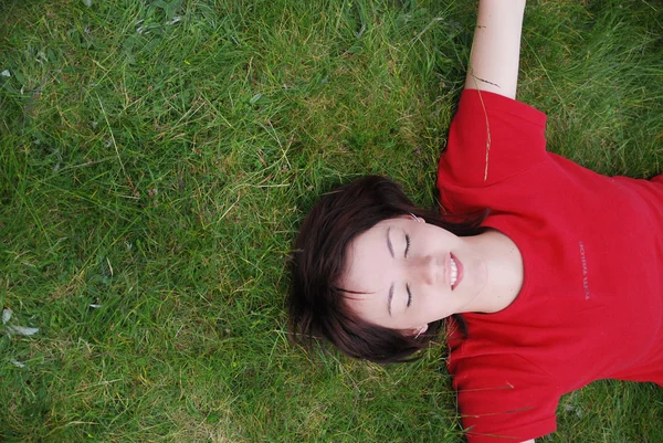 Vrouw in gras te leggen — Stockfoto