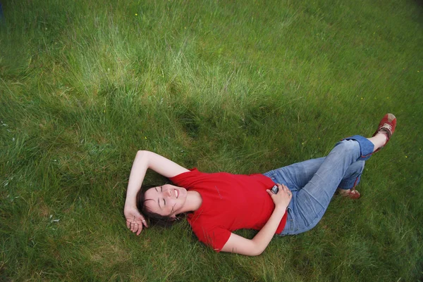 Frau liegt im Gras — Stockfoto