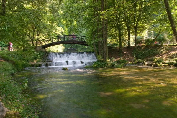 Holzbrücke über kleinen Wasserfall — Stockfoto