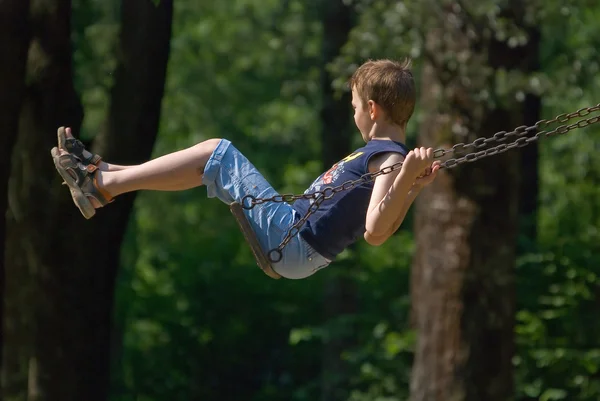Boy swinging in park — Stock Photo, Image