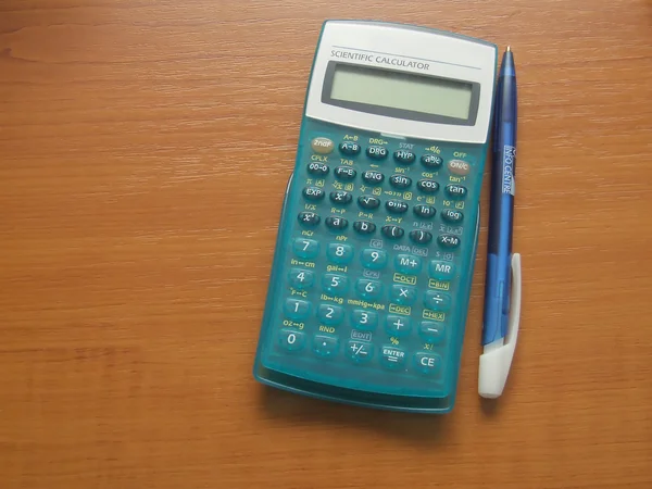 Научный калькулятор на коричневом столе — стоковое фото