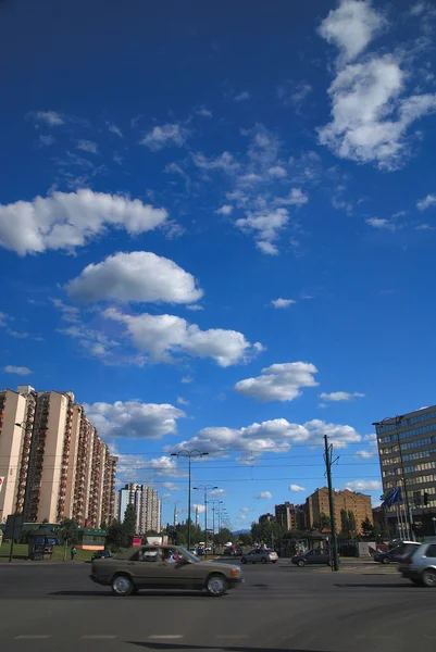 Трафік у місті та блакитне небо з драматичними хмарами — стокове фото