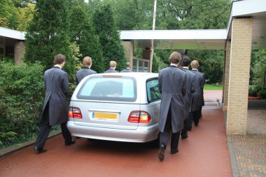 Grey hearse entering cemetery clipart