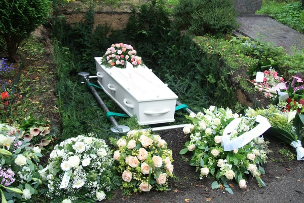 White coffin with pink sympathy flowers — Stock Photo, Image