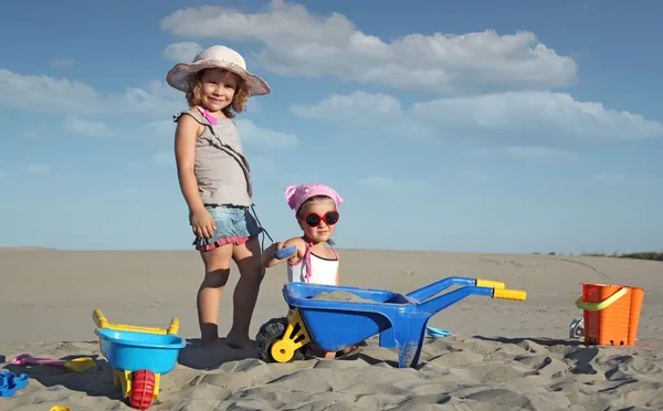 2 つの小さな女の子の楽しいと砂で遊ぶ — ストック写真