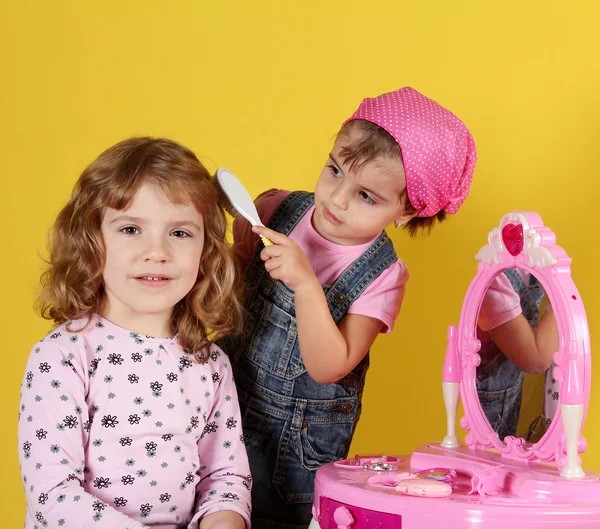 Две маленькие девочки играют в парикмахерскую — стоковое фото