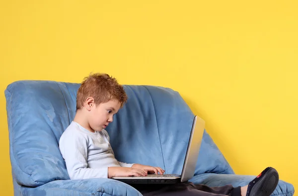 Мальчик печатает на ноутбуке — стоковое фото
