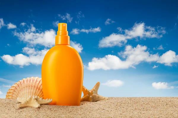 Summer holiday - suntan oil on beach — Stock Photo, Image