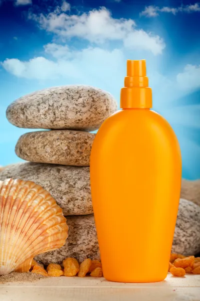 Sunbath - suntan oil, shell and stones — Stock Photo, Image