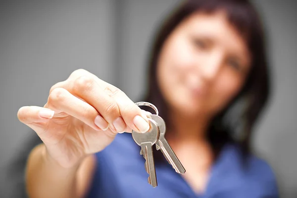 Realtor in empty apartment giving keys — Stock Photo, Image