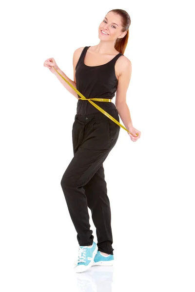 Mulher fitness com fita métrica no fundo branco — Fotografia de Stock