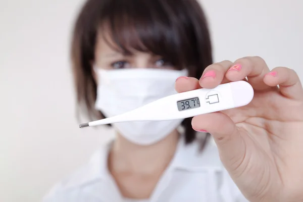 Médica feminina segurando termômetro médico — Fotografia de Stock