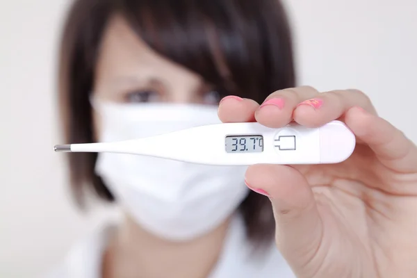 Female doctor holding medical thermometer — Stock Photo, Image