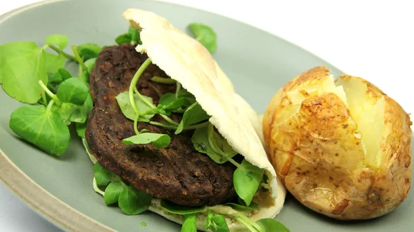 Hambúrguer vegetariano em pão Pitta com batata assada Imagens De Bancos De Imagens Sem Royalties