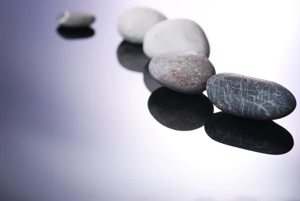 Pebbles and shadows on smooth background — Stock Photo, Image