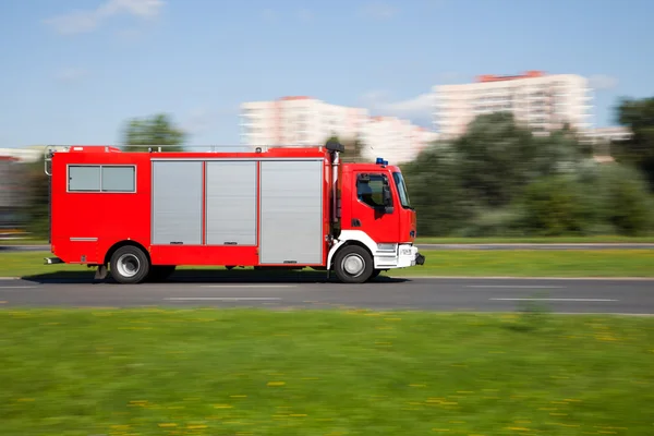 Panning image of a fire truck rushing on the street — Stock Photo, Image