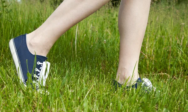 Walking on green grass in sport shoes — Stock Photo, Image