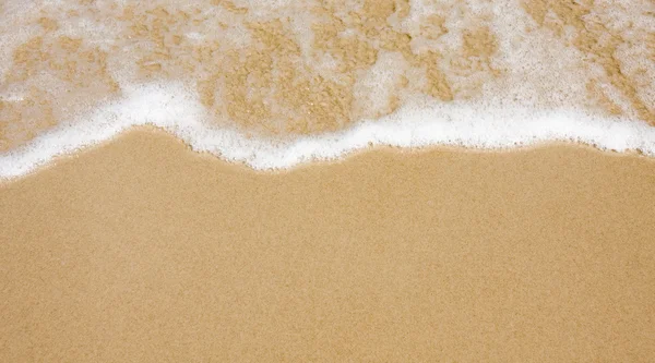 Welle am klaren Sandstrand — Stockfoto