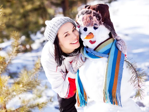 Женщина со снеговиком — стоковое фото