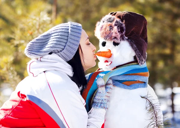 Vrouw met een sneeuwpop — Stockfoto