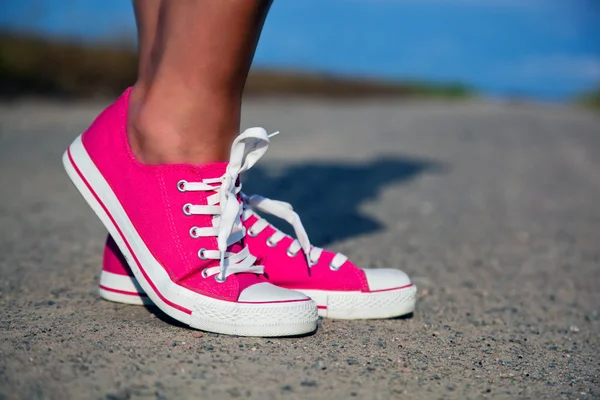 Рожеві кросівки на дівчині, жіночі ноги — стокове фото