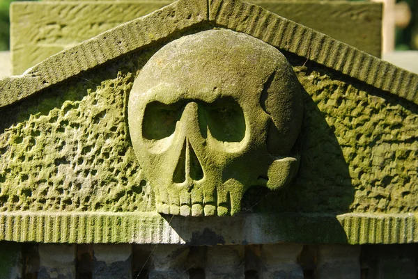 Cráneo de piedra viejo del cementerio — Foto de Stock
