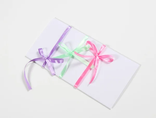 O cartão decorado com uma fita colorida e arco — Fotografia de Stock