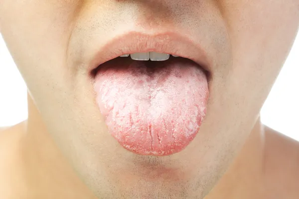 Крупним планом молоді чоловіки показують язик ізольований на білому тлі — стокове фото