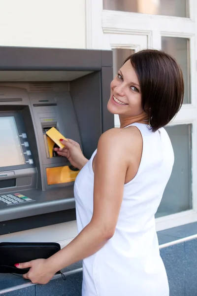 Vrouw neemt geld op van creditcard bij ATM — Stockfoto