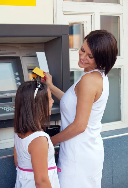 Glückliche Familie hebt am Geldautomaten Geld von Kreditkarte ab — Stockfoto