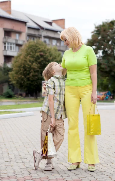 Мать и сын гуляют с сумками — стоковое фото
