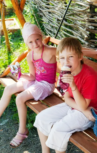Två barn äta glass i park — Stockfoto