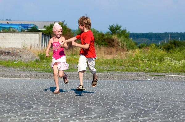 Crianças felizes correndo na rua — Fotografia de Stock