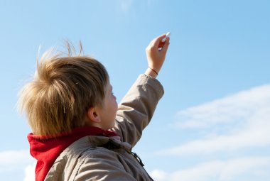 The boy drawing a chalk on cloudy sky clipart