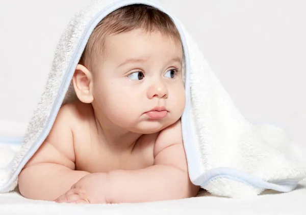 Маленький ребенок под белым полотенцем — стоковое фото