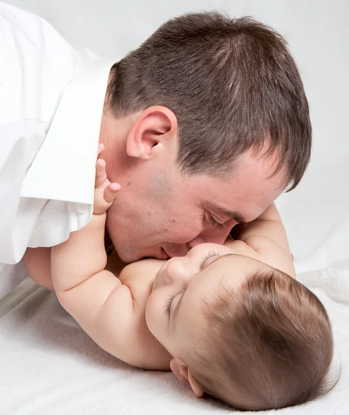 Szczęśliwa rodzina, ojciec i dziecko na białym łóżku — Zdjęcie stockowe